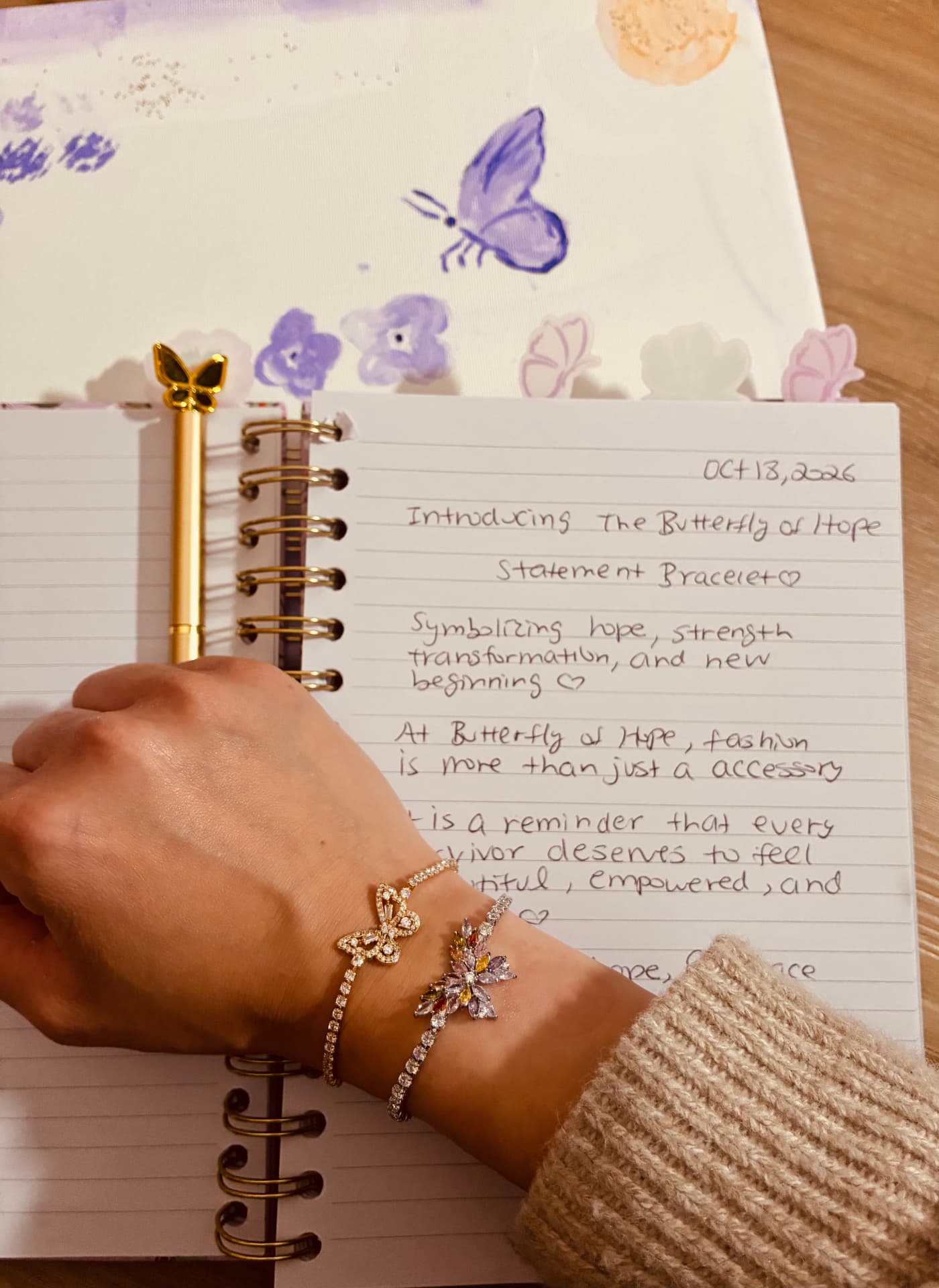 Wings of Hope butterfly bracelet worn on the wrist above an open journal