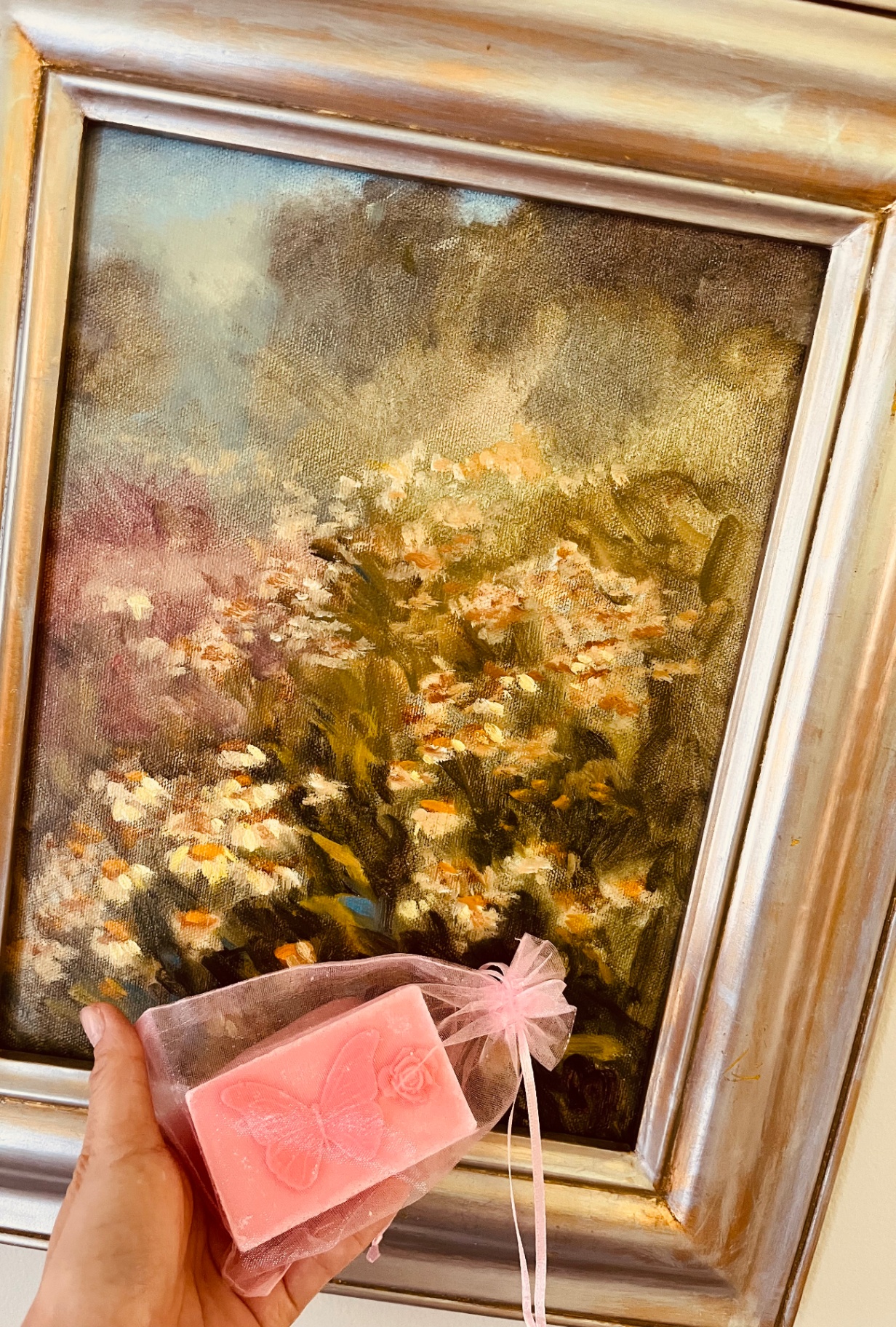Pink butterfly soap held against a golden wildflower field oil painting