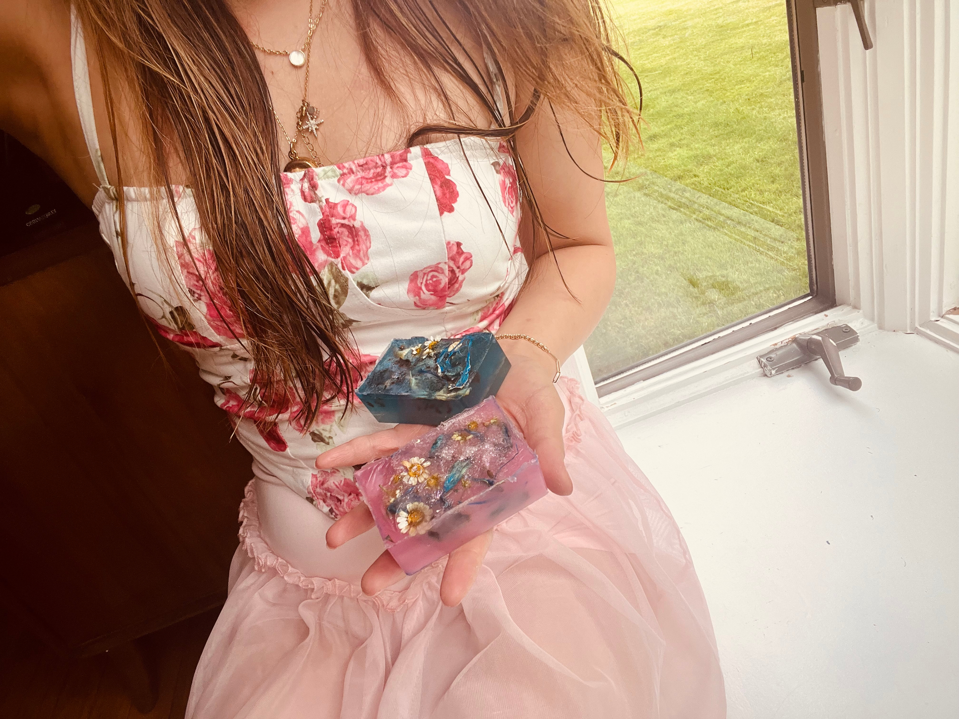Founder of Butterfly of Hope holding two handcrafted floral soaps