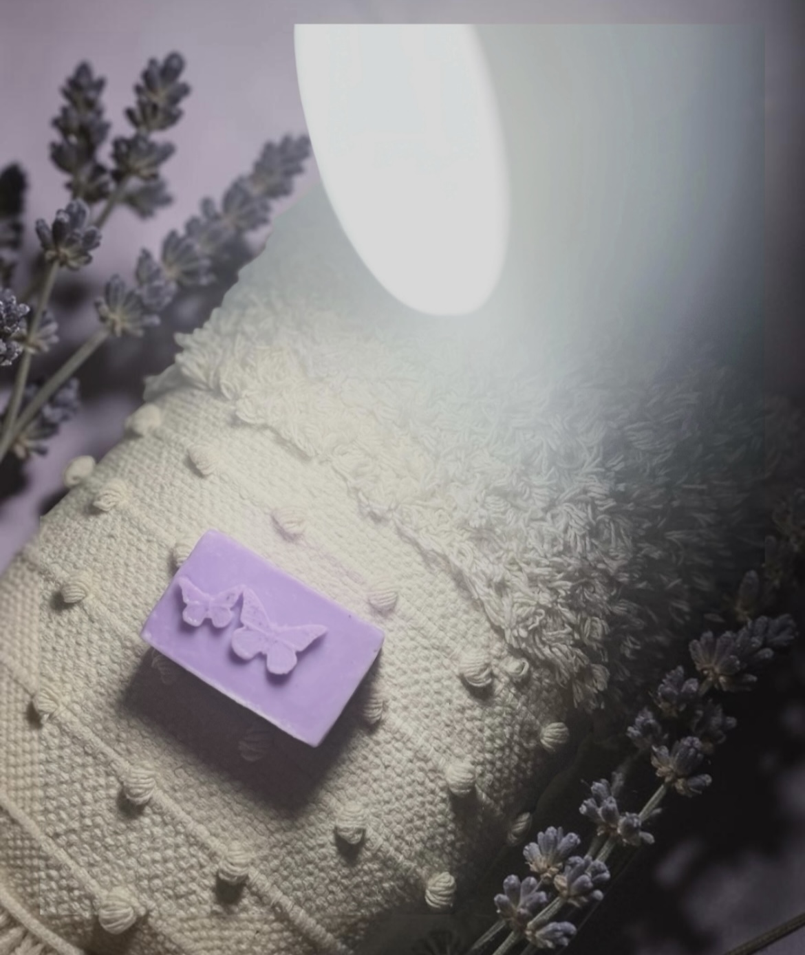 Lavender butterfly soap resting on knit cotton with fresh lavender sprigs
